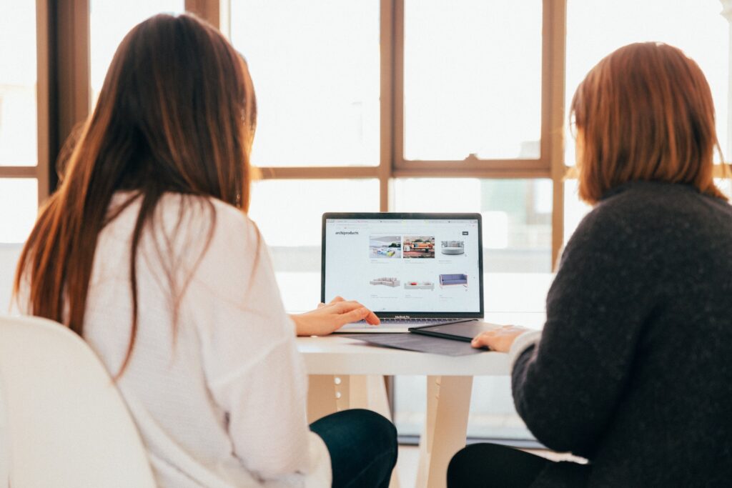 person shadowing another working at a laptop