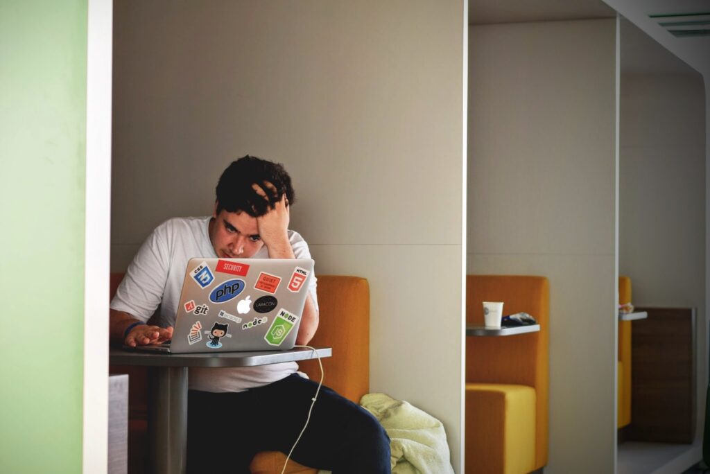 frustrated man sitting with laptop at a table